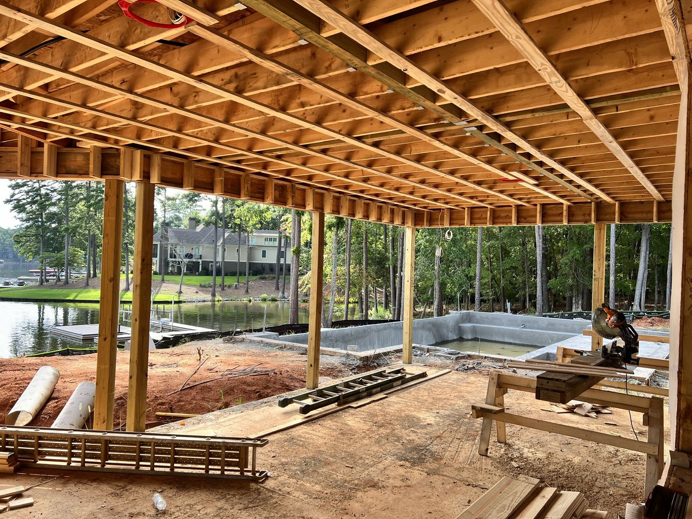 Framed deck structure overlooking a lake and pool